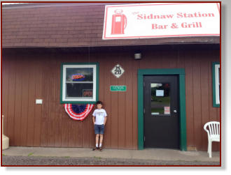 Photo of boy in front of Sidnaw Station. Sidnaw Michigan